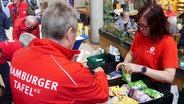 Zwei Mitarbeiter der Hamburger Tafel sortieren Lebensmittelspenden, die in einem Einkaufszentrum gespendet wurden. © picture alliance 