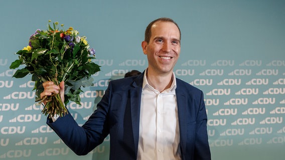 Der CDU-Landesvorsitzende Dennis Thering hält nach seiner Wahl auf Platz Eins der Landesliste zur Bürgerschaftswahl 2025 einen Blumenstrauß bei der Landesvertreterversammlung der CDU Hamburg. © picture alliance/dpa | Markus Scholz Foto: Markus Scholz