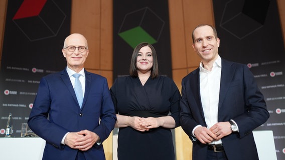 Die Bürgermeisterkandidaten in Hamburg, Peter Tschentscher (SPD), Katharina Fegebank (Grüne) und Dennis Thering (CDU) stehen beim "Rathaus-Triell" nebeneinander. © picture alliance/dpa | Marcus Brandt Foto: Marcus Brandt