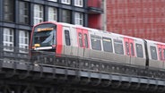 Eine U-Bahn der Linie U3 fährt auf einer erhobenen Trasse in Hamburg. © picture alliance/dpa 