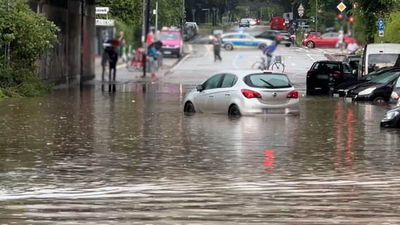 Ein Auto steht in einer durch ein Unwetter überfluteten Straße in Hamburg. © NDR 