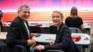 Jan van Aken und Ines Schwerdtner sitzen beim Bundesparteitag der Partei Die Linke in Halle/Saale nebeneinander. © Hendrik Schmidt/dpa 