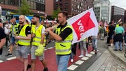 Der Demonstrationszug zieht an der Zentrale des Hafenlogistikers HHLA vorbei. © NDR 