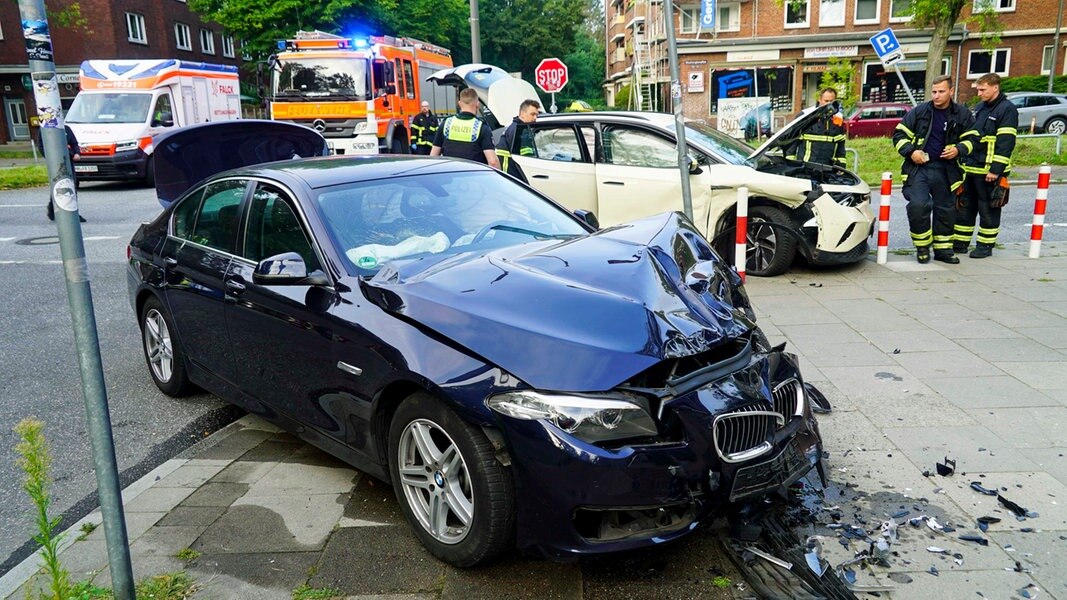 Zwei beschädigte Autos stehen nach einem Verkehrsunfall an einer Kreuzung in Hamburg.
