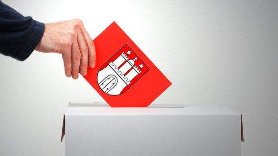 Eine Hand hält einen roten Umschlag mit Hamburg-Wappen in einen Wahl-Urnenschlitz (Fotomontage) © Fotolia Foto: kebox