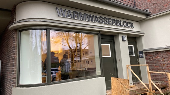 Auf einem Gebäude steht die Aufschrift "Warmwasserblock". © NDR Foto: Reinhard Postelt