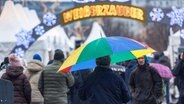 Ein Mann geht im Nieselregen mit seinem Schirm über einen Weihnachtsmarkt. © picture alliance/dpa | Markus Scholz Foto: Markus Scholz