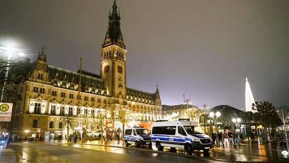 Polizeifahrzeuge stehen am Weihnachtsmarkt vor dem Hamburger Rathaus. © picture alliance / ABBFoto 