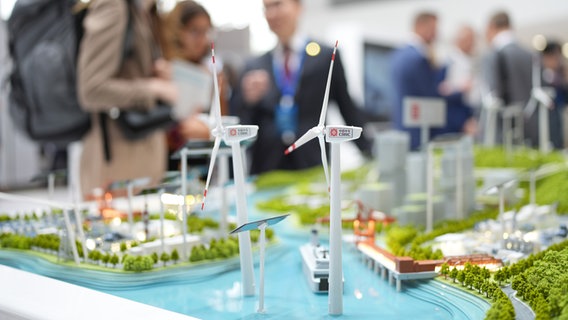 Messebesucherinnen stehen am Stand des chinesischen Windenergieanlagen-Herstellers CRRC in einer Messehalle auf der Messe WindEnergy Hamburg. © picture alliance / dpa Foto: Marcus Brandt