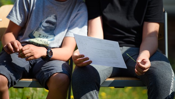 Zwei Jungen schauen sich am letzten Schultag vor den Sommerferien ein Zeugnis an © picture alliance/dpa Foto: Gregor Fischer