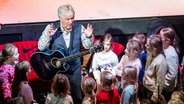 Der Sänger Rolf Zuckowski singt in Hamburg gemeinsam mit Kindern bei der Veranstaltung "Der große Weihnachtsbäckerei-Kindertag". © picture alliance / dpa Foto: Axel Heimken