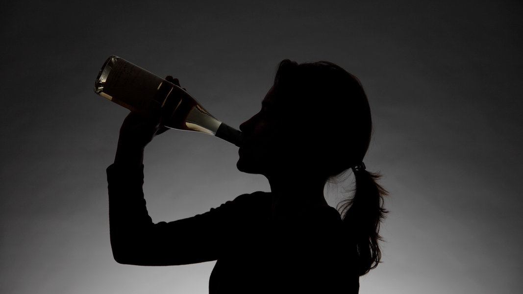 Eine Frau trinkt Alkohol aus einer Flasche