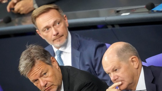 Christian Lindner (M, FDP), Bundesminister der Finanzen, Robert Habeck (l, Bündnis 90/Die Grünen), Bundesminister für Wirtschaft und Klimaschutz, und Bundeskanzler Olaf Scholz (SPD) nehmen an der Sitzung des Bundestags teil. © dpa bildfunk Foto: Kay Nietfeld