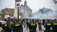 Sicherheitskräfte ergreifen Maßnahmen, während Fans von Maccabi Tel Aviv am Dam-Platz eine pro-israelische Demonstration veranstalten, bei der sie vor dem UEFA-Europa-League-Spiel zwischen Maccabi Tel Aviv und Ajax am 7. November 2024 in Amsterdam, Niederlande, Leuchtraketen zünden und Parolen rufen. © picture alliance / Anadolu | Mouneb Taim Foto: Mouneb Taim