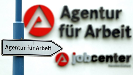 Ein Schild weist den Weg zur Agentur für Arbeit. © Jan Woitas/dpa 