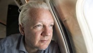 Wikileaks-Gründer Julian Assange sitzt in einem Flugzeug. © dpa bildfunk/@wikileaks/PA Wire 