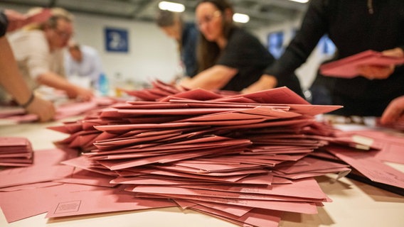 Briefwahlstimmen liegen zur Auszählung auf einem Tisch. © dpa Foto: Christophe Gateau