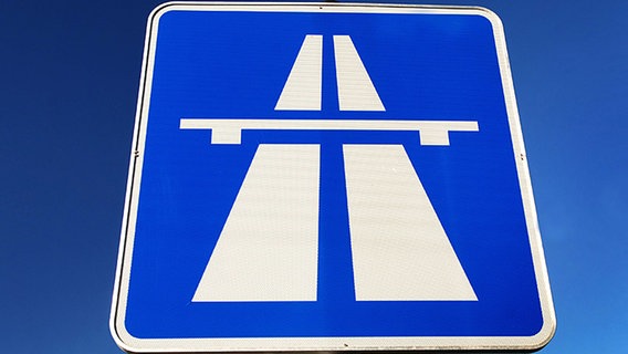 Ein Autobahnschild vor blauem Hintergrund. © dpa/picture-alliance 