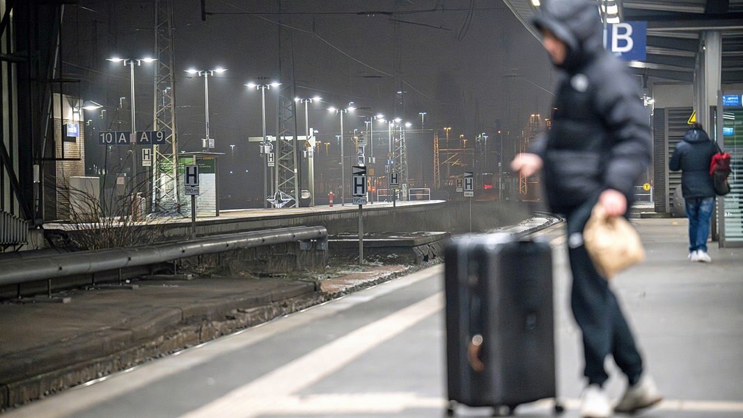 Ein Reisender steht im Dunklen am Bremer Hauptbahnhof.