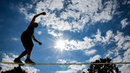 Ein Mensch balanciert auf einer Slackline vor blauem Himmel © picture alliance/dpa Foto: Jan Woitas