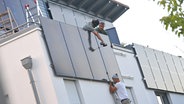 Arbeiter bei der Montage von Solarpanels an der Fassade eines Hauses © picture alliance / SVEN SIMON Foto:  Frank Hoermann / SVEN SIMON