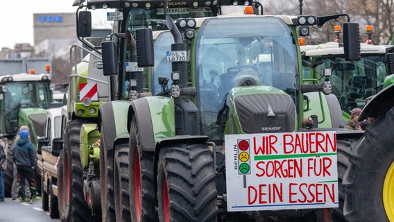 Ein Schild mit der Abbildung einer Ampel und der Aufschrift "Wir Bauern sorgen für dein Essen" ist auf einem Traktor auf der Bismarckstraße angebracht. © dpa Foto: Monika Skolimowska