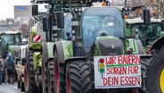 Ein Schild mit der Abbildung einer Ampel und der Aufschrift "Wir Bauern sorgen für dein Essen" ist auf einem Traktor auf der Bismarckstraße angebracht. © dpa Foto: Monika Skolimowska