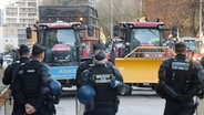 Polizeibeamte blockieren Landwirte, die mit ihren Traktoren auf der Straße in Straßburg gegen das Mercosur-Handelsabkommen protestieren. © Jean-Francois Badias/AP/dpa 