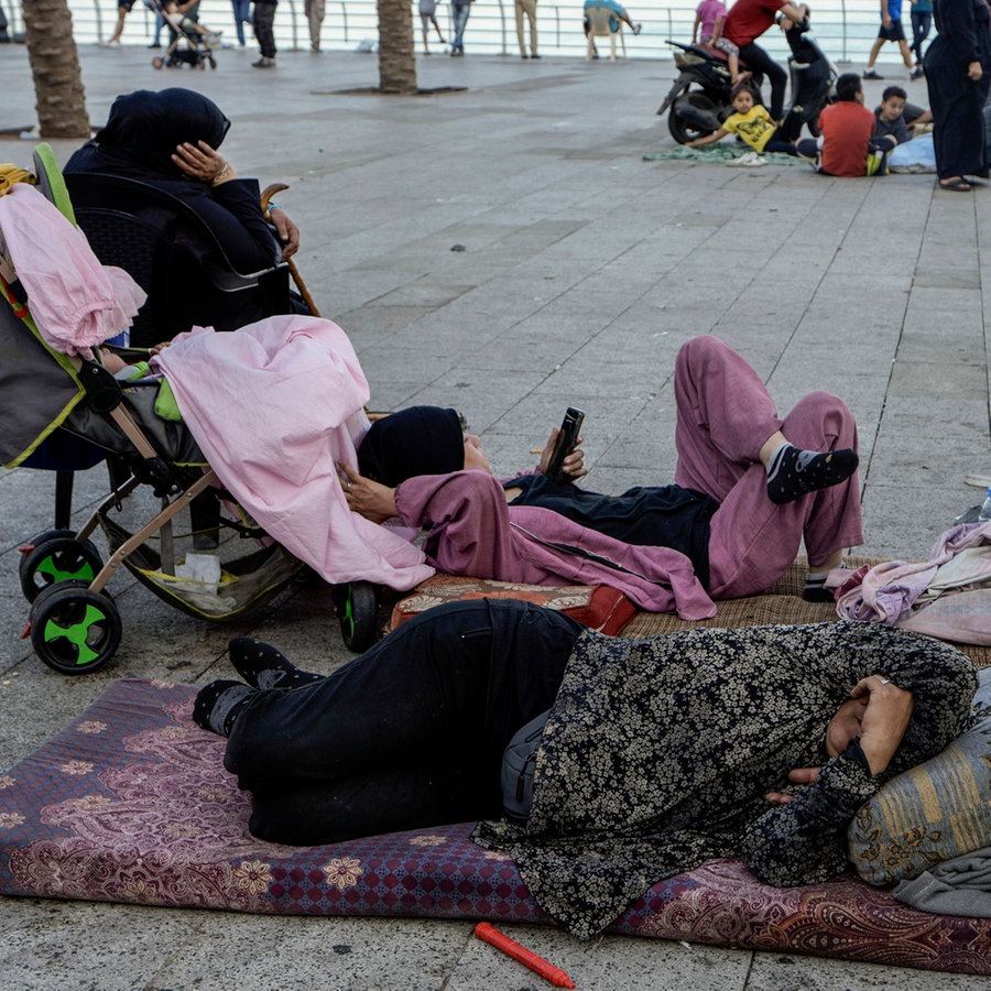 Familien schlafen auf der Corniche von Beirut, nachdem sie vor den israelischen Luftangriffen in den südlichen Vororten von Dahiyeh geflohen sind. © Bilal Hussein/AP/dpa 