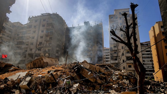 Rauchschwaden steigen zwischen den Trümmern von Gebäuden auf, die bei einem israelischen Luftangriff auf einen südlichen Vorort von Beirut zerstört wurden. © dpa Foto: Marwan Naamani