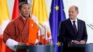 German Chancellor Olaf Scholz, right, and Bhutan's Prime Minister Lotay Tshering, left, address the media during a joint press conference at the chancellery in Berlin. © picture alliance Foto: Michael Sohn
