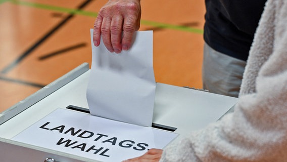 Eine Person gibt seine Stimme zur Landtagswahl in Brandenburg in einem Wahllokal ab. © dpa Foto: Patrick Pleul