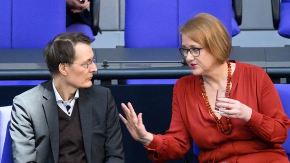 Bundesgesundheitsminister Karl Lauterbach (SPD) und Bundesfamilienministerin Lisa Paus (Grüne) unterhalten sich bei einer Plenarsitzung im Bundestag. © Bernd von Jutrczenka/dpa 