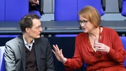 Bundesgesundheitsminister Karl Lauterbach (SPD) und Bundesfamilienministerin Lisa Paus (Grüne) unterhalten sich bei einer Plenarsitzung im Bundestag. © Bernd von Jutrczenka/dpa 