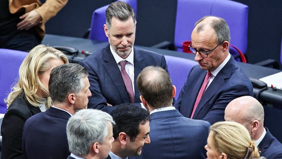 Der CDU-Vorsitzende Friedrich Merz spricht im Bundestag mit dem FDP-Fraktionsvorsitzenden Christian Dürr und weiteren Abgeordneten. © dpa-bildfunk Foto:  Hannes P. Albert