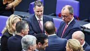 Der CDU-Vorsitzende Friedrich Merz spricht im Bundestag mit dem FDP-Fraktionsvorsitzenden Christian Dürr und weiteren Abgeordneten. © dpa-bildfunk Foto:  Hannes P. Albert