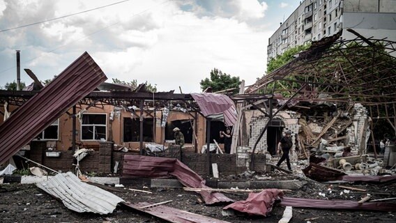 Ein Feuerwehrmann geht durch den Qualm eines brennenden Hauses, nach russischen Beschuss. © Ukrinform/dpa 