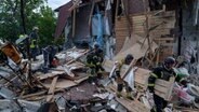 Rettungskräfte räumen die Trümmer eines durch einen russischen Luftangriff zerstörten Gebäudes. © Evgeniy Maloletka/AP 