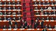 Delegierte sitzen beim chinesischen Volkskongress in der Großen Halle des Volkes in Peking. © dpa-Bildfunk/AP Foto: Ng Han Guan