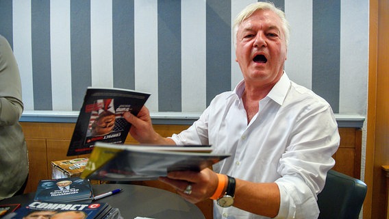 Herausgeber Jürgen Elsässer verkauft an einem Stand auf dem Landesparteitages der AfD Sachsen-Anhalt sein "Compact"-Magazin. © dpa picture alliance Foto: Klaus-Dietmar Gabbert