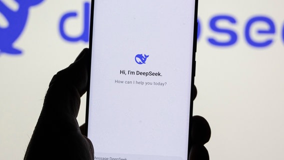 Ein Mann hält ein Smartphone mit dem Logo des chinesischen KI Startup DeepSeek in der Hand © picture alliance / NurPhoto Foto: Nicolas Economou