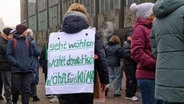 Während einer Demonstration gegen rechts in Bremen trägt eine Teilnehmerin ein Plakat auf dem Rücken mit der Aufschrift: "Geht wählen, wählt demokratisch, wählt fürs Klima". © Izabela Mittwollen/dpa 