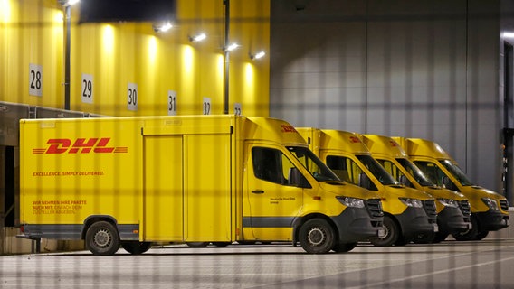 Zustellfahrzeuge der DHL stehen streikbedingt auf einem Hof des Unternehmens. © IMAGO / HEN-FOTO 