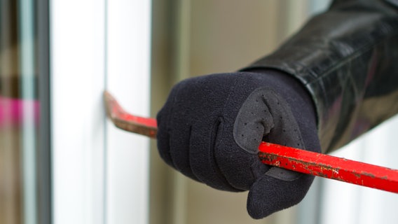 Einbrecher hebelt mit einem Brecheisen ein Fenster auf. © Fotolia.com Foto: sdecoret