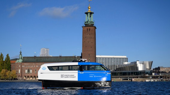 Die elektrische Tragflächenfähre Nova bewegt sich während eines Tests, mit dem Stockholmer Rathaus im Hintergrund, in Stockholm. © dpa-Bildfunk Foto: Henrik Montgomery/TT News Agency/AP/dpa