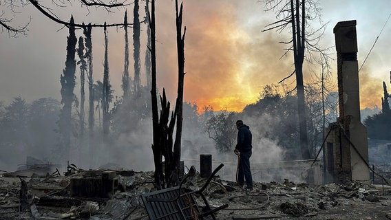 Ein Anwohner steht vor den Überresten eines bei einem Waldbrand in Kalifornien abgebrannten Hauses. © dpa bildfunk/AP Foto: Eugene Garcia