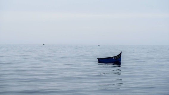 Ein leeres Holzboot treibt im Atlantik. © IMAGO Foto: Tim Röhn