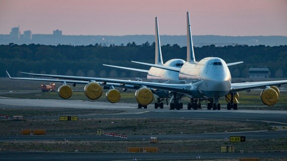 Mit abgedeckten Turbinen stehen vorübergehend stillgelegte Passagiermaschinen der Lufthansa auf dem Rollfeld des Frankfurter Flughafens © picture alliance/dpa Foto: Boris Roessler