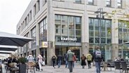 Passanten gehen auf der Breiten Strasse in der Innenstadt am Kaufhaus von Karstadt vorbei. © picture alliance/dpa Foto: Markus Scholz