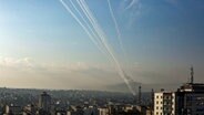 Am Himmel über Gaza-Stadt sind Raketen zu sehen, die in Richtung Israel fliegen. © Mohammed Talatene/dpa 